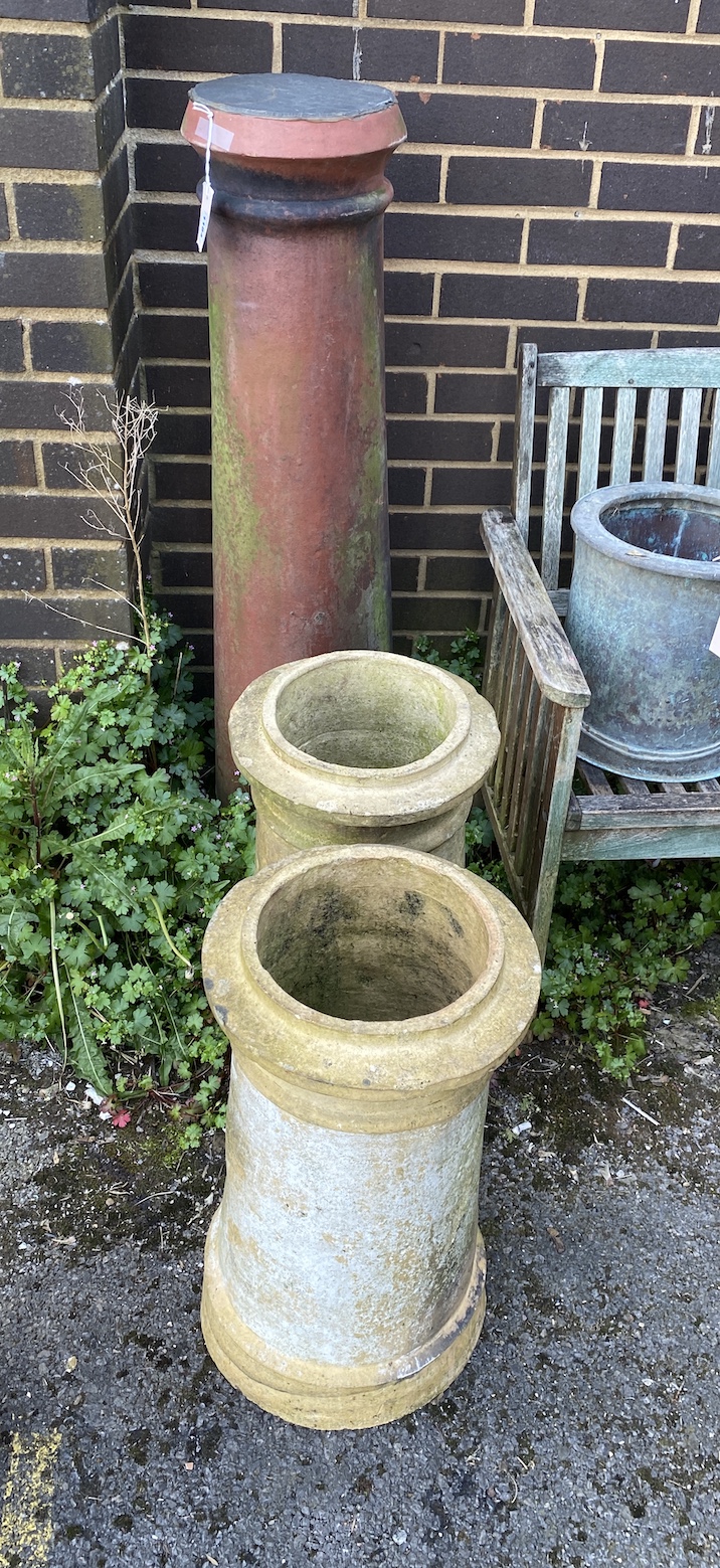 Three earthenware chimney pots, two as garden planters and one as a plinth with slate top, largest 120cm